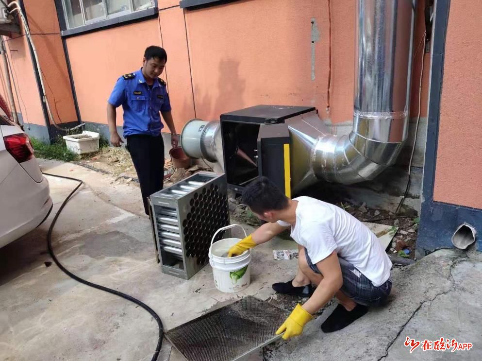 兰山区金雀山街道清泉庄社区城管人员监督辖区餐饮单位清洗油烟净化器