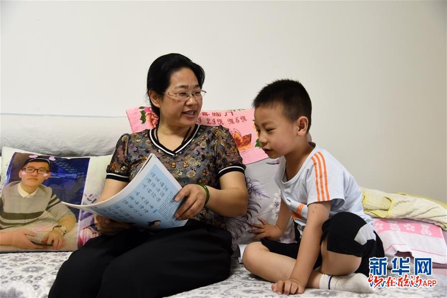 5月30日,志愿者谢成凤(左)和帮扶儿童徐同成一同背诵《弟子规》.