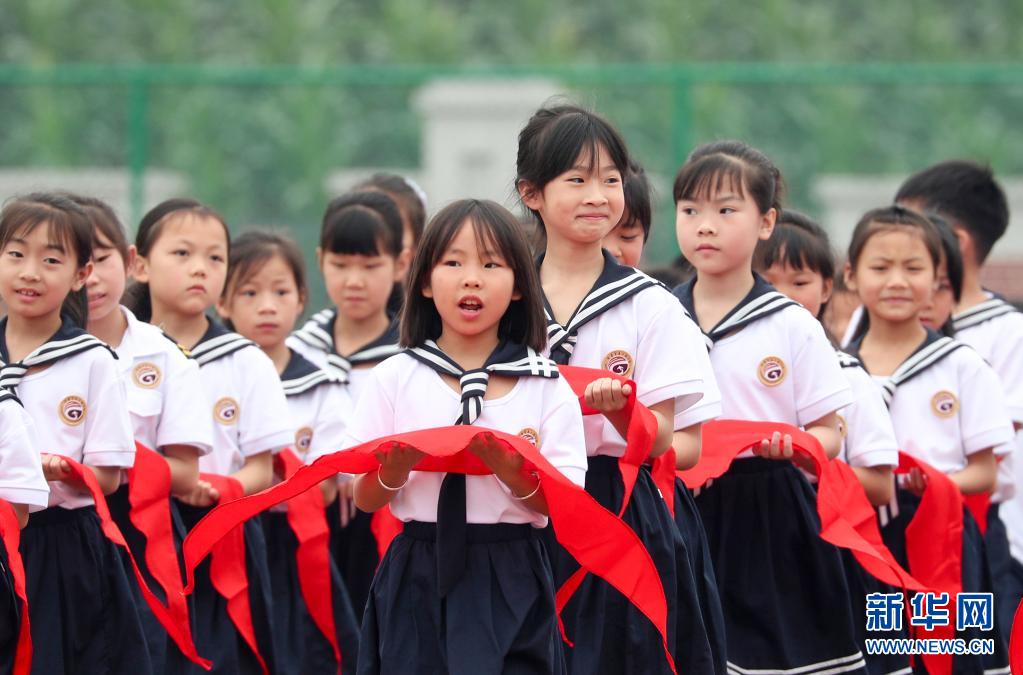 5月31日,四川省华蓥市高兴镇小学学生手捧红领巾参加入队仪式.